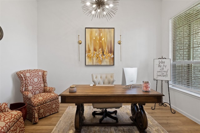 office space with an inviting chandelier and light hardwood / wood-style flooring