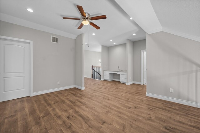 unfurnished living room featuring ceiling fan, wood-type flooring, and built in desk