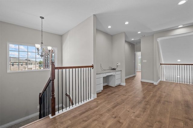 corridor with plenty of natural light, a chandelier, and light hardwood / wood-style floors