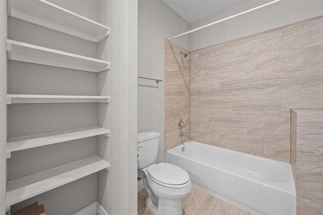 bathroom with toilet and tiled shower / bath combo