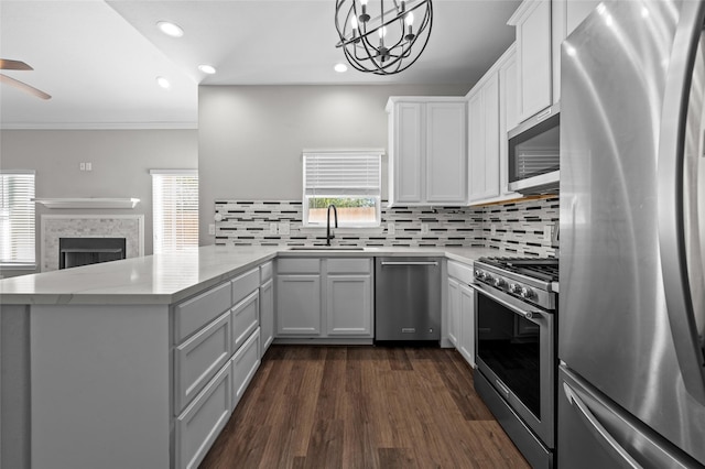 kitchen with stainless steel appliances, kitchen peninsula, sink, and white cabinets