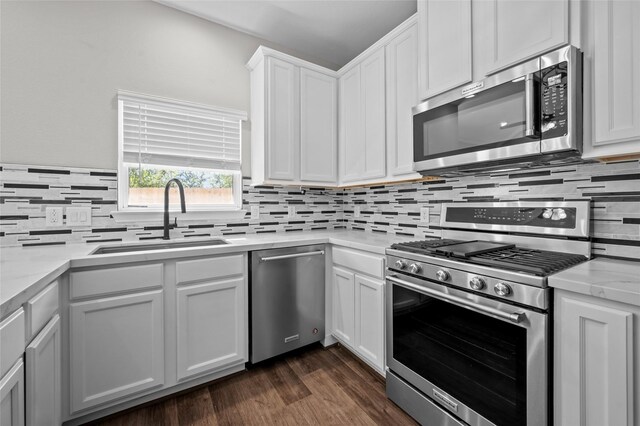 kitchen with sink, light stone countertops, white cabinets, and appliances with stainless steel finishes