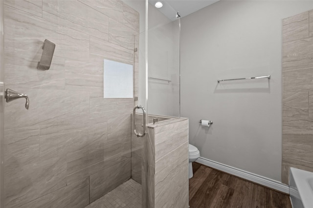 bathroom featuring wood-type flooring, a shower with shower door, and toilet