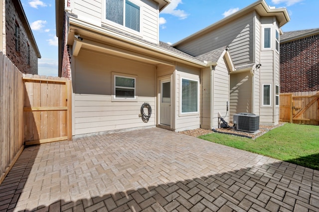 rear view of house featuring central AC unit and a patio area