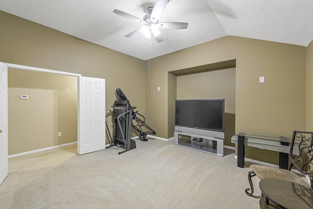 exercise area featuring lofted ceiling, light colored carpet, a textured ceiling, and ceiling fan