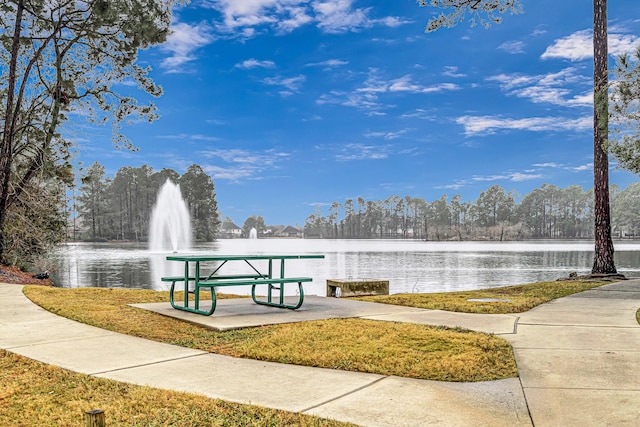 view of community with a water view and a yard