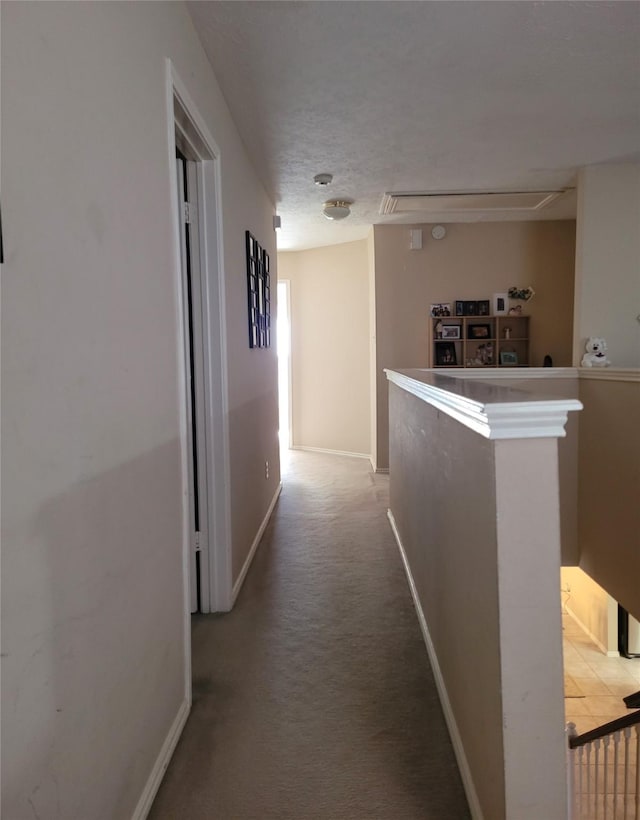 corridor with carpet flooring and a textured ceiling