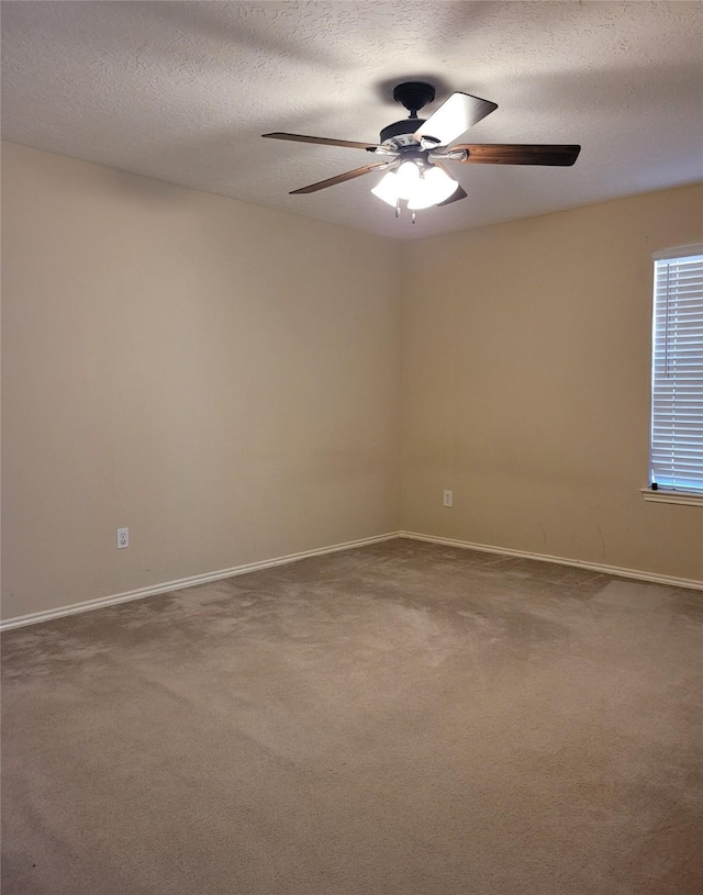 spare room featuring ceiling fan, carpet, and a textured ceiling