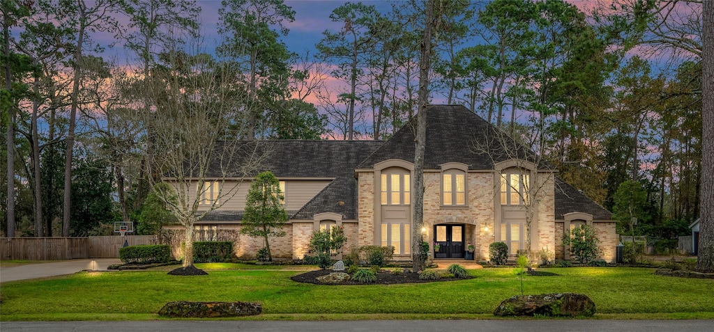 view of front of home with french doors and a lawn