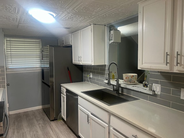 kitchen featuring sink, dishwasher, backsplash, light hardwood / wood-style floors, and white cabinets