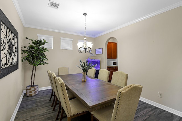 dining area with crown molding, dark wood-type flooring, and a notable chandelier