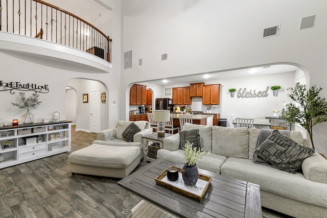 living room with dark hardwood / wood-style floors and a towering ceiling