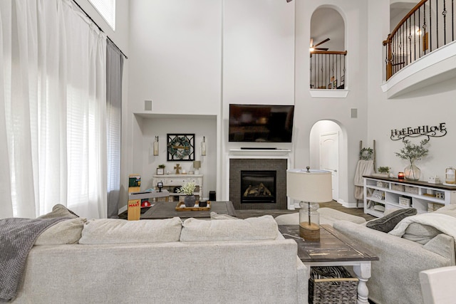 living room featuring ceiling fan, hardwood / wood-style floors, and a high ceiling