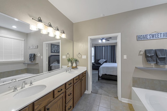 bathroom with tile patterned floors, a bathing tub, and vanity