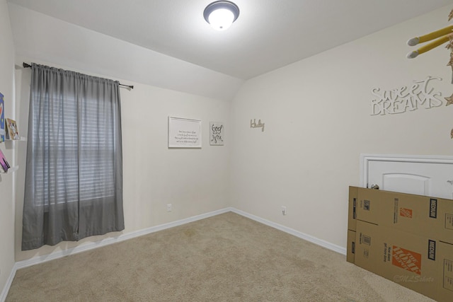 carpeted empty room featuring lofted ceiling