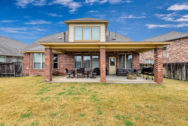 rear view of property featuring an outdoor living space, a yard, and a patio area