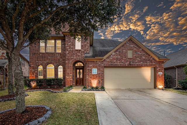 view of front of property featuring a garage and a yard