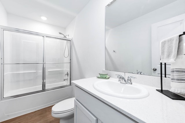 full bathroom with enclosed tub / shower combo, vanity, toilet, and hardwood / wood-style floors