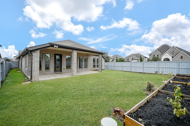 rear view of property with a yard and a patio