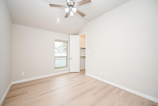 unfurnished room with lofted ceiling, ceiling fan, and light hardwood / wood-style flooring