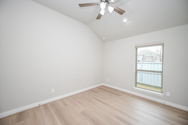 spare room featuring lofted ceiling, ceiling fan, and light wood-type flooring