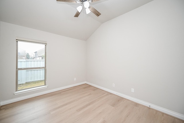 empty room featuring ceiling fan, lofted ceiling, a healthy amount of sunlight, and light wood-type flooring