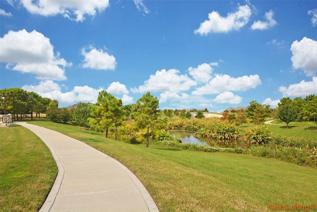 view of home's community with a water view and a yard