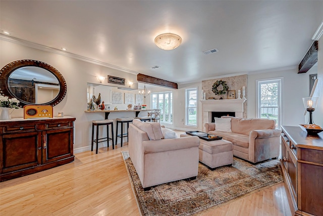 living room with ornamental molding, a healthy amount of sunlight, and light hardwood / wood-style floors