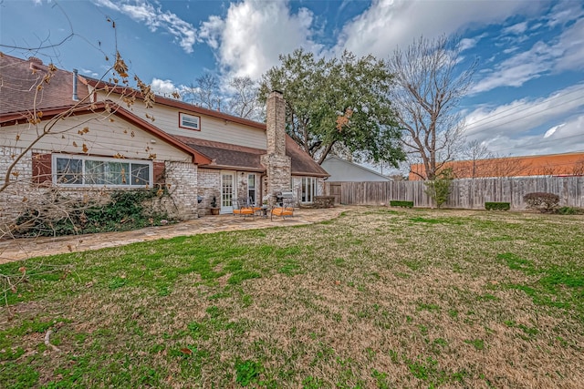 back of house with a yard and a patio