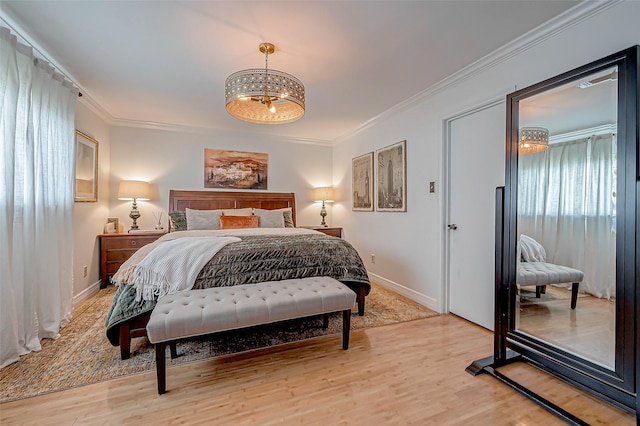 bedroom with crown molding, an inviting chandelier, and light hardwood / wood-style floors