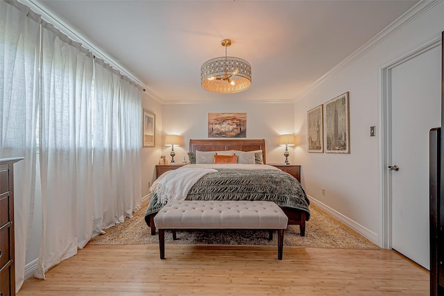 bedroom featuring ornamental molding and light wood-type flooring