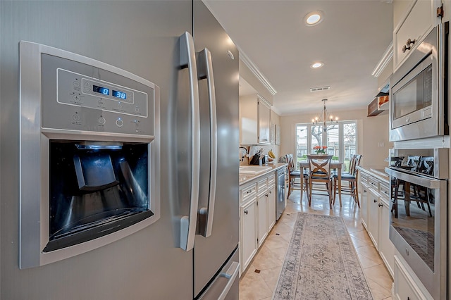 kitchen featuring white cabinetry, appliances with stainless steel finishes, pendant lighting, and light tile patterned floors