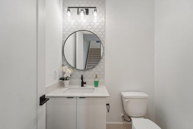 bathroom with vanity, backsplash, and toilet