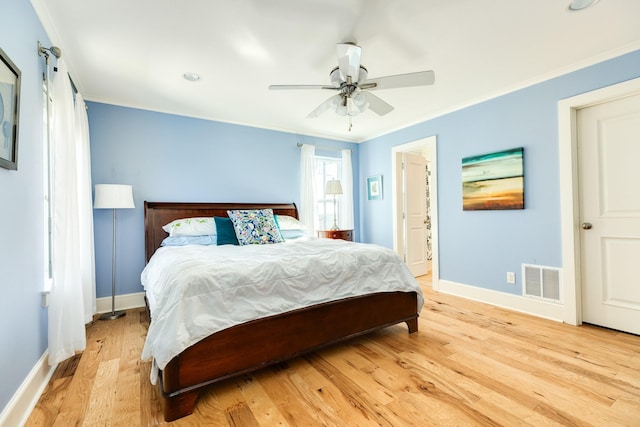 bedroom featuring ornamental molding, light hardwood / wood-style floors, and ceiling fan