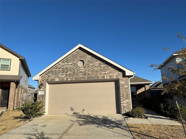 view of front of home with concrete driveway, brick siding, an attached garage, and fence