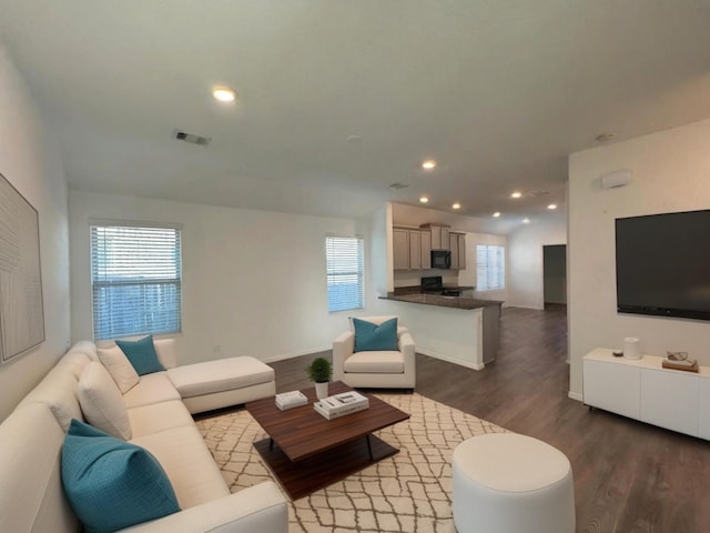 living area featuring recessed lighting, visible vents, baseboards, and wood finished floors