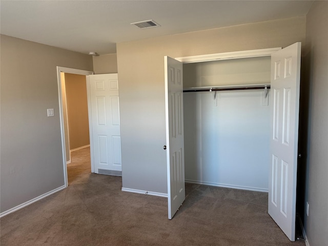 unfurnished bedroom with a closet, visible vents, baseboards, and carpet flooring