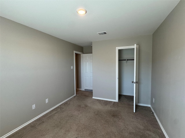 unfurnished bedroom with visible vents, baseboards, carpet, a spacious closet, and a closet