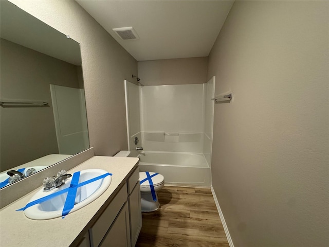 full bath with visible vents, bathing tub / shower combination, toilet, wood finished floors, and vanity