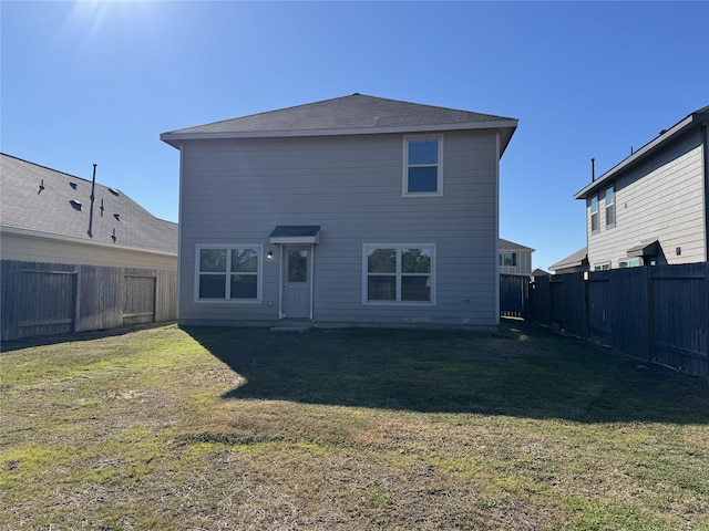 back of house with a yard and a fenced backyard