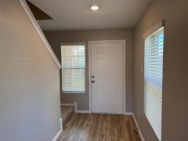 doorway to outside with baseboards and wood finished floors