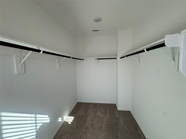 walk in closet featuring visible vents and dark colored carpet