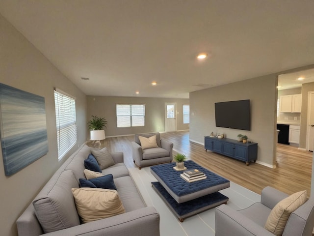 living area featuring recessed lighting, baseboards, and light wood finished floors