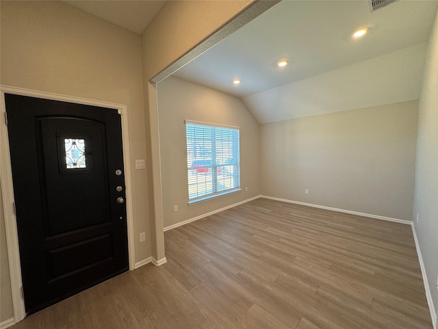 entrance foyer featuring vaulted ceiling and wood-type flooring