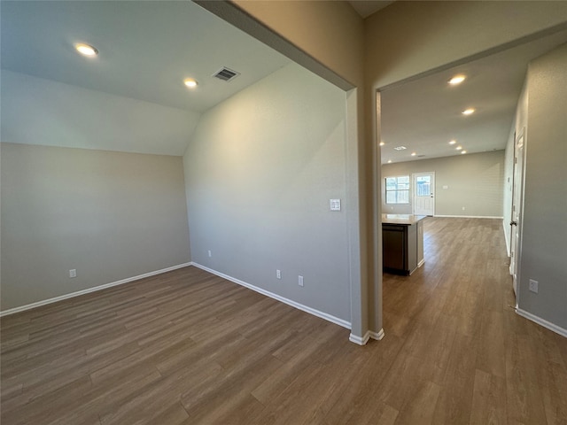 interior space featuring dark hardwood / wood-style flooring and vaulted ceiling