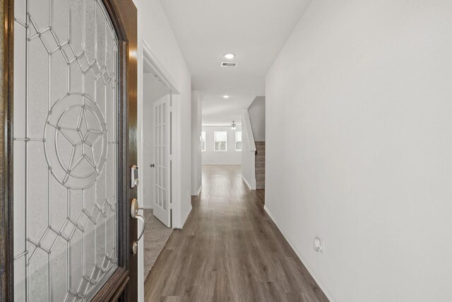 corridor with hardwood / wood-style flooring