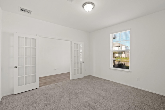 spare room with carpet and french doors