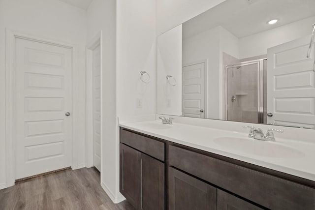 bathroom featuring vanity, hardwood / wood-style floors, and a shower with shower door