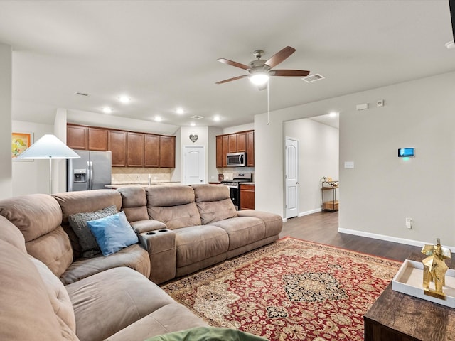 living room with ceiling fan and dark hardwood / wood-style floors