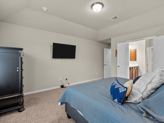 carpeted bedroom featuring vaulted ceiling and ensuite bathroom